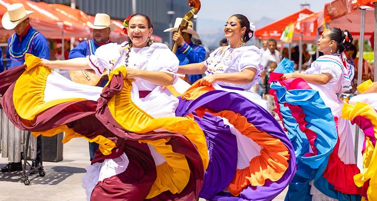 Des gens qui célèbrent en robes traditionnelles colorées, en train de danser.