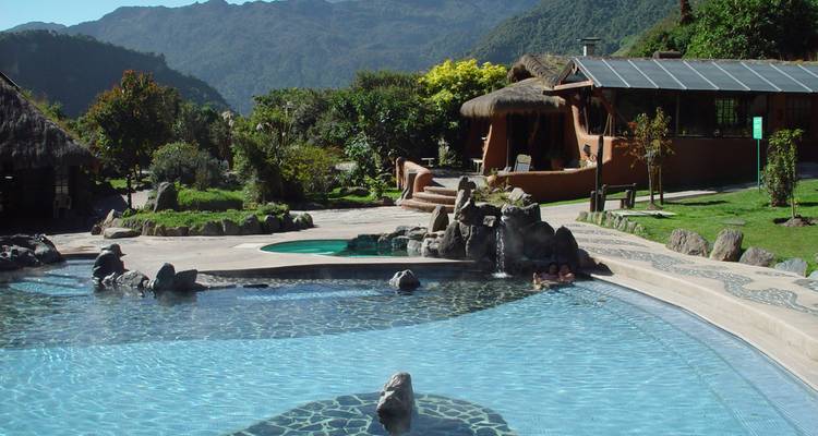 Inviting thermal pool complex with natural stone edges set amid tropical gardens and mountain views.