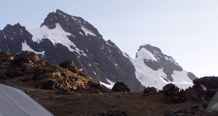 Jagged snow-coated Andean peaks rise sharply against a clear sky.