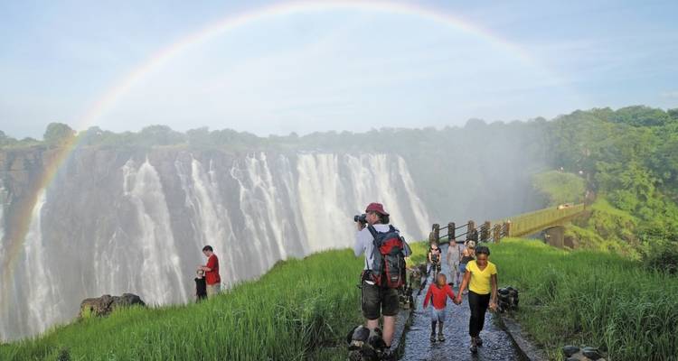 Victoria Falls met regenboog en toeristen.