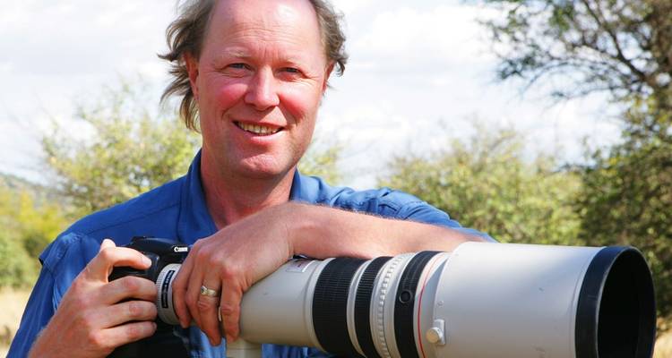 Man met camera in buitenomgeving.