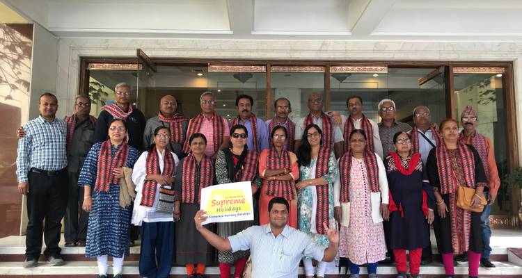 Ein Gruppenfoto vor einem Gebäude mit einem Reiseführer-Schild.