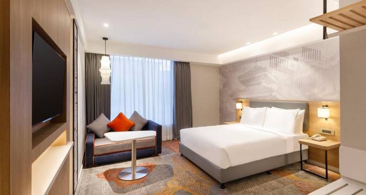 Hotelzimmer mit einem komfortablen Doppelbett und moderner Einrichtung.