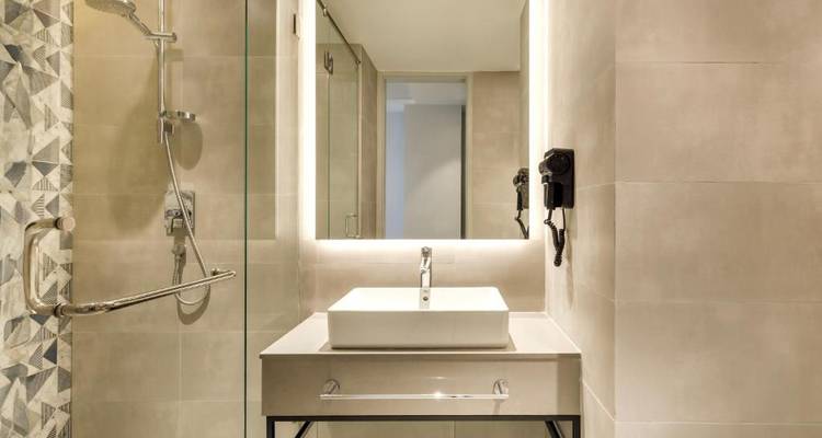 Modernes Badezimmer mit Duschbereich und einem gut beleuchteten Spiegel.