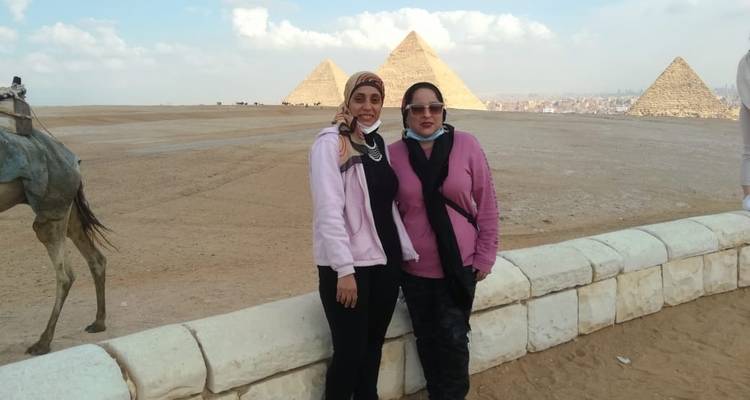 Twee mensen poseren met de piramides op de achtergrond.