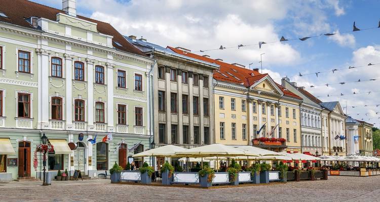 Pastel-colored facades with outdoor cafés line Tartu’s cobbled Town Hall Square.