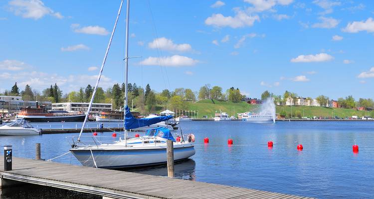 Voilier amarré à un quai avec vue sur l'eau et les collines à Lappeenranta.