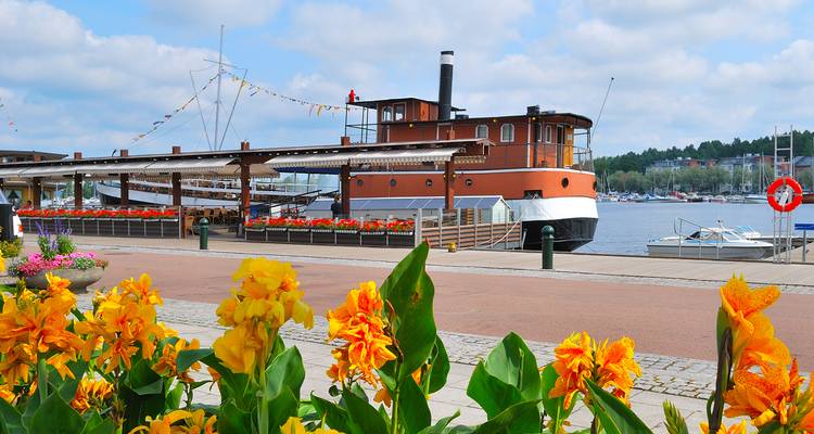 Fleurs au premier plan avec un bateau et de l'eau à Lappeenranta.
