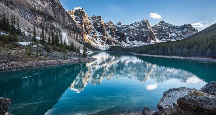 Le lac Moraine aux eaux cristallines reflétant les pics enneigés et les forêts de conifères dans le parc national de Banff.