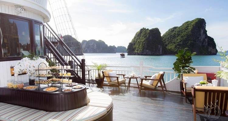 Eine elegante Lounge-Umgebung auf einem Boot mit Blick auf das Meer und Felsformationen.