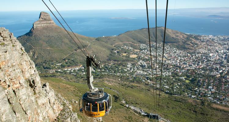 Cable car overlooking a city with mountains in the background.