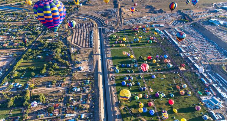 Luchtfoto van heteluchtballonnen boven een groot veld.