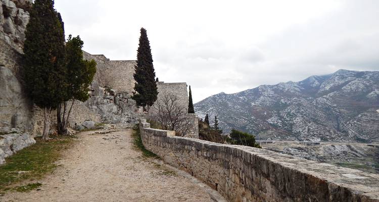 Steinpfad entlang der Festungsmauer mit Bergkulisse identisch mit der früheren Aussicht von Klis