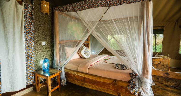 Interior of a well-decorated safari tent with a bed.
