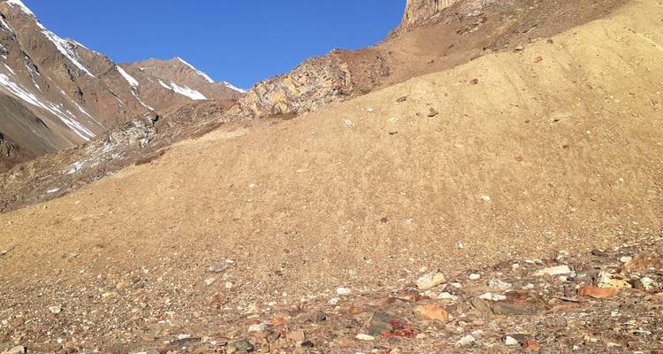 Arid mountainous landscape with rocky slopes under a clear blue sky.