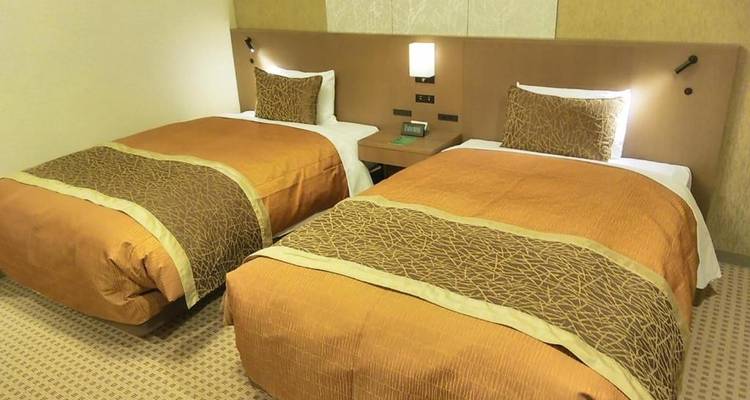 Hotelzimmer mit zwei Einzelbetten und traditioneller Einrichtung.