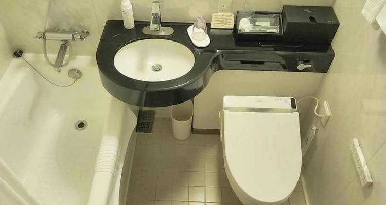 Badezimmer mit Badewanne und Toilette mit Marmor-Design.