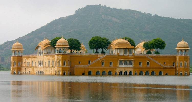 Palace partially submerged in water with hills in the background.