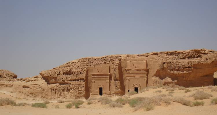 Ancient rock-cut buildings in a desert setting.