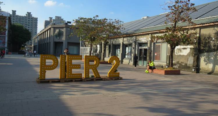 PIER-2 bord op een buitenplein met mensen.