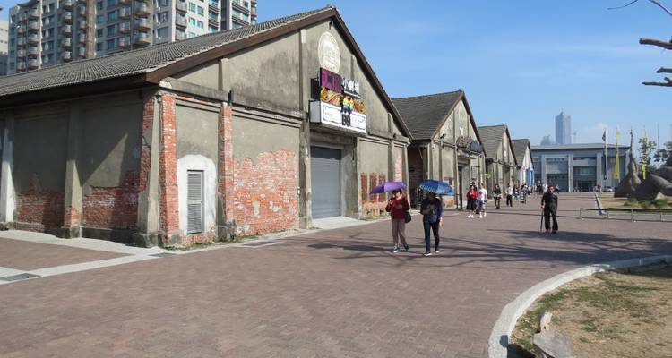 Oude industriële gebouwen met wandelende mensen.