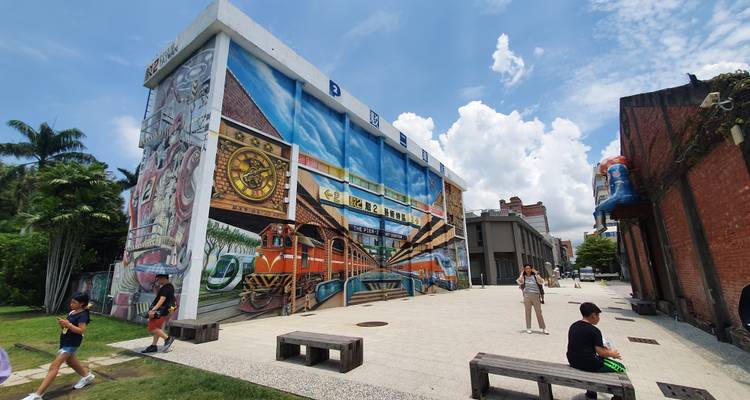 Gebouw met muurschildering van treinen en klokken.