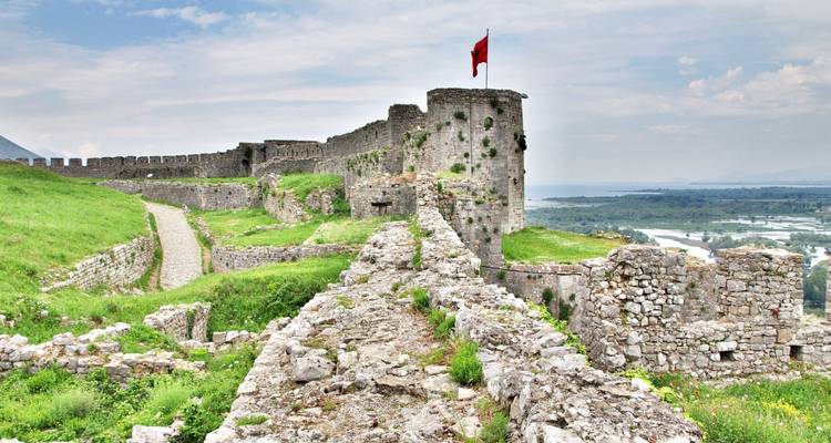 Alte Steinfestung mit einer roten Fahne und weitläufigen Ausblicken.