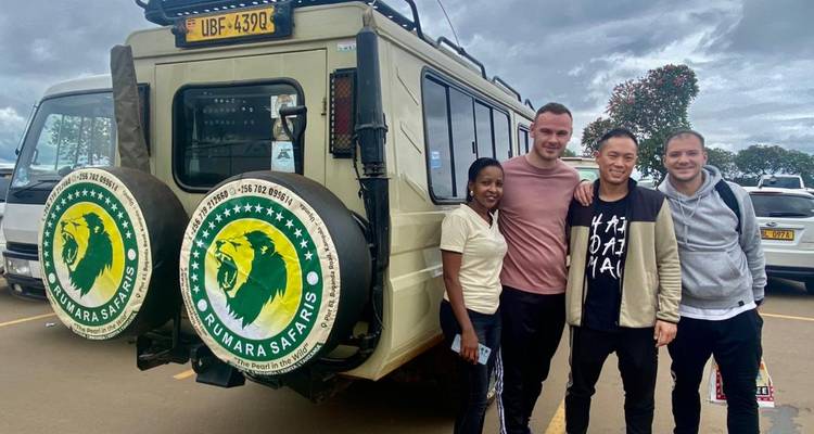 Groep die poseert voor een safarivoertuig op een bewolkte dag.