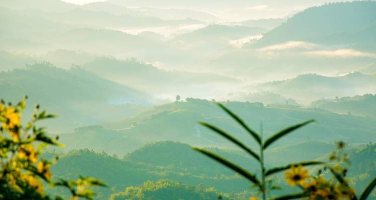 Neblige Berge mit durchscheinenden Sonnenstrahlen.