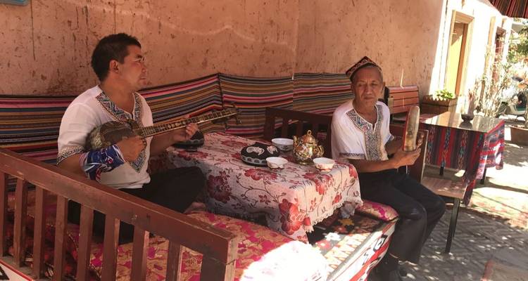 Twee mannen die muziekinstrumenten bespelen op een kleurrijke bank.