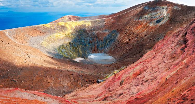 Un cratère volcanique coloré avec des dépôts minéraux variés.