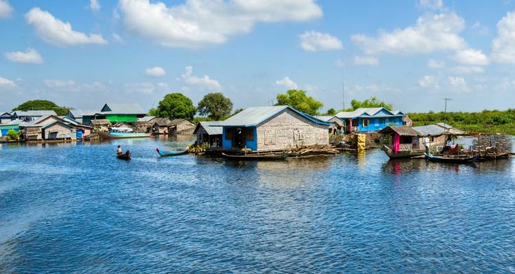 Floating village on Tonle Sap Lake with blue waters.