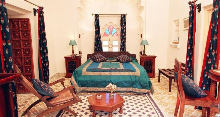 Luxueuze hotelkamer met traditionele inrichting en vloertegels.