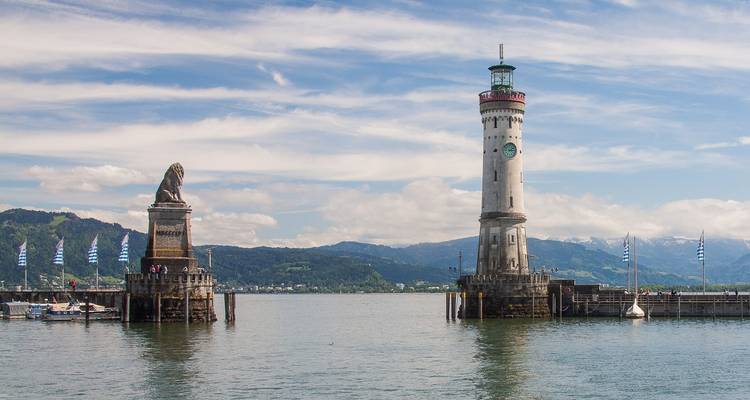 Faro y estatua de león en la entrada de un puerto.