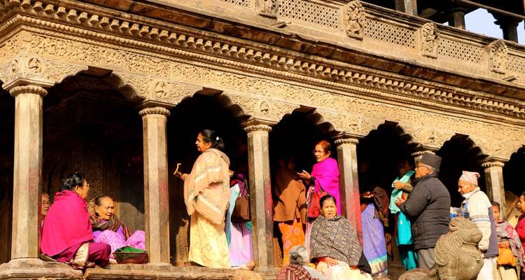 Close-up of people sitting under a beautifully carved decorative structure.