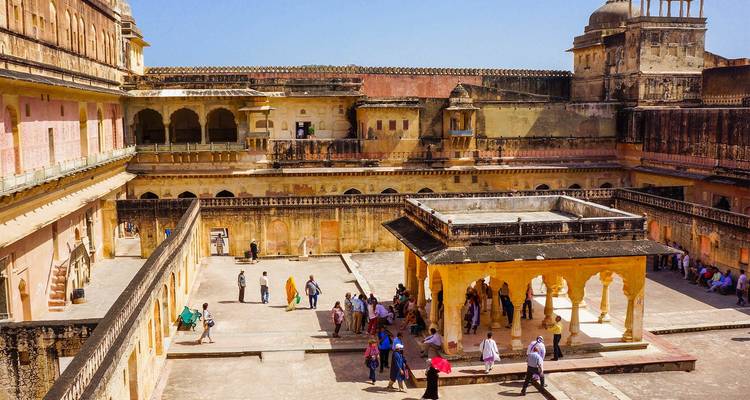 An ancient courtyard with people walking around.