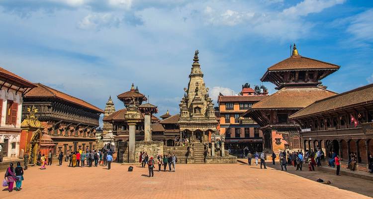 A historic square with traditional buildings and a crowd of people.