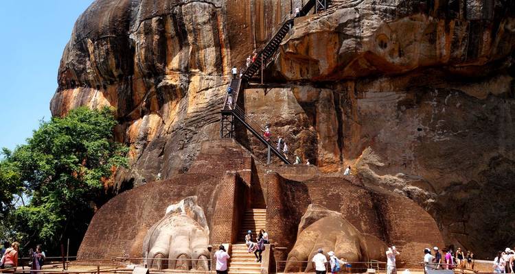 Besucher, die die Stufen einer alten Felsfestung erklimmen.