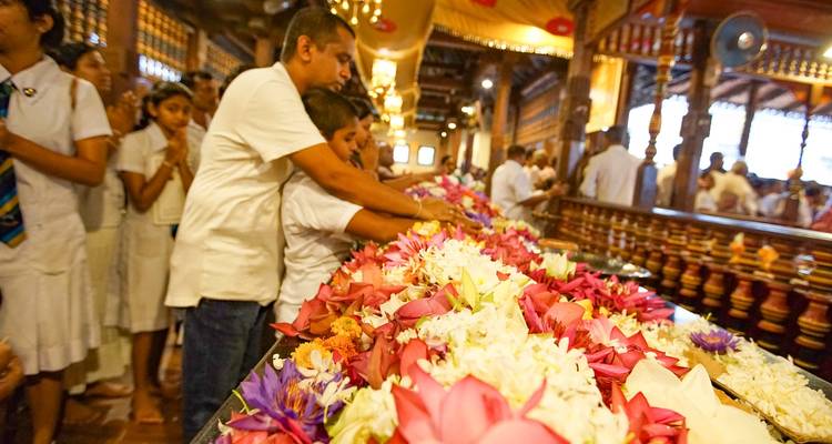 Menschen, die Blumen in einem Tempel darbringen.