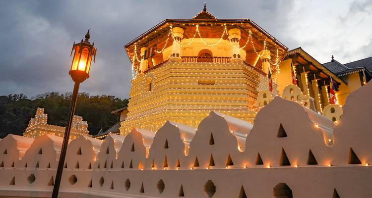 Ein Tempel, der nachts mit dekorativen Lichtern beleuchtet ist.