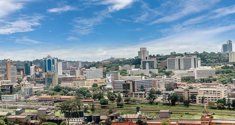 Amplio horizonte del centro moderno de Kampala con cielos azules y nubes dispersas arriba.