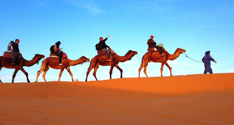 Wüstenkarawane mit einer Reihe von Kamelen und Reitern