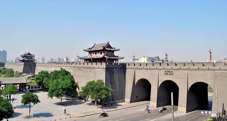 Ancient city wall with a road beside it.