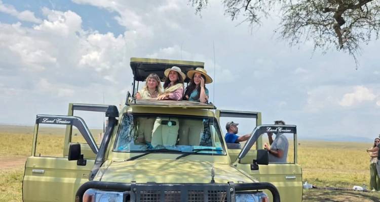 Groupe de personnes dans un véhicule de safari dans la savane.