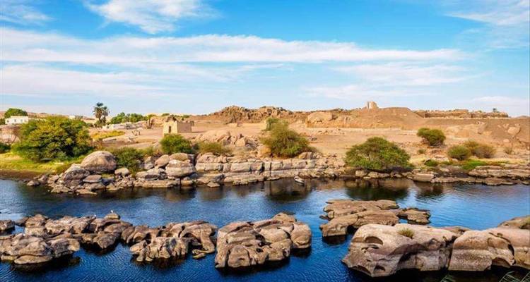 Grasige Ufer mit Felsvorsprüngen an einem Fluss.