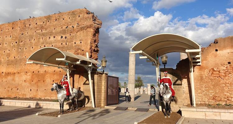 Twee wachters te paard bij een oude muur.