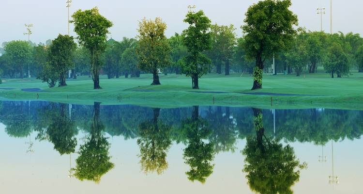 Spiegelung von Bäumen im Wasser auf einem Golfplatz