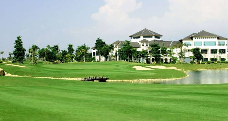 Eine malerische Aussicht auf einen Golfplatz mit einem Clubhaus im Hintergrund.