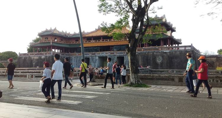 Toeristen lopen voor een traditioneel Vietnamees gebouw.