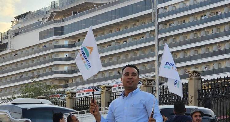 Gids die vlaggen vasthoudt voor een groot cruiseschip.